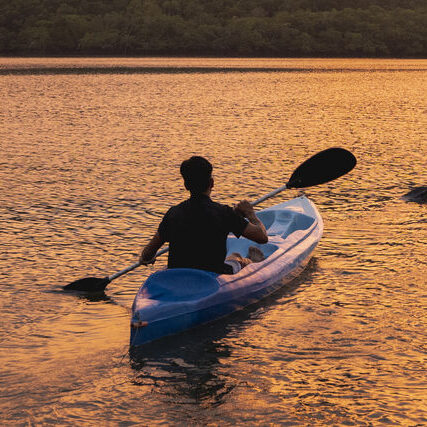 Two people kayaking in a lagoon at sunset